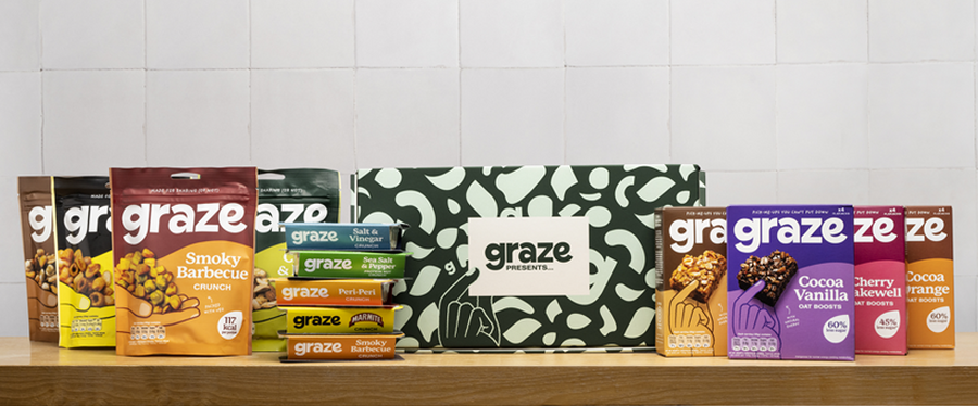 A shelf of a colourful variety of graze snacks, including sharing bags, punnets, oat boosts and a graze presents subscription box