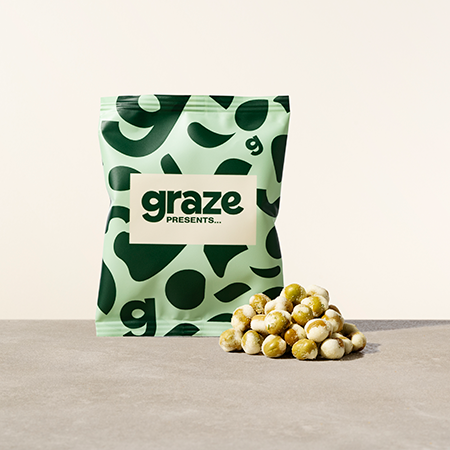 A pile of Graze's dill peas in front of the packaging
