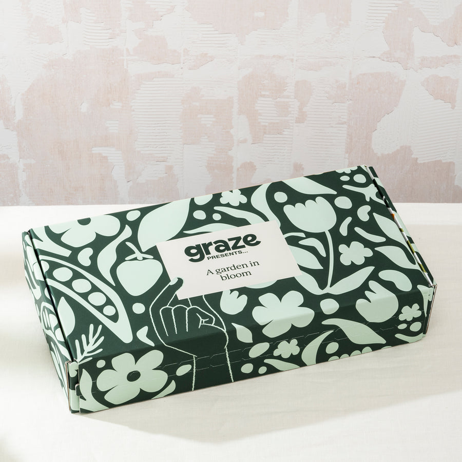 The Graze Presents 'a garden in bloom' closed box with green and floral patterns featuring garden themes