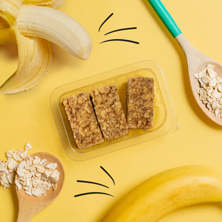punnet with banana flapjack and bananas and oats scattered around it