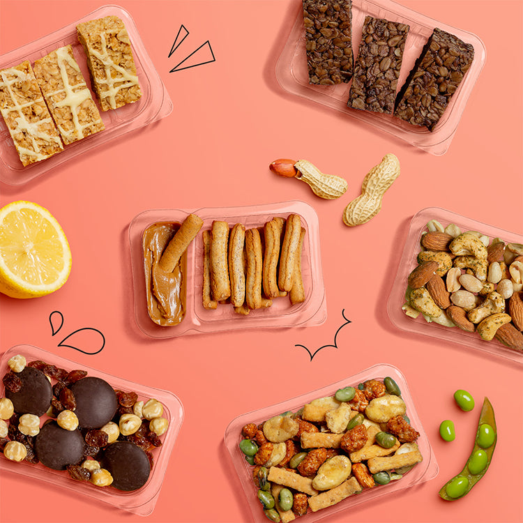 six scattered punnets containing: cocoa vanilla flapjack, lively lemon flapjack, Belgian Speculoos dipper, our version of jaffa cake, punchy chilli & lime nutty protein power and Thai style sweet chilli